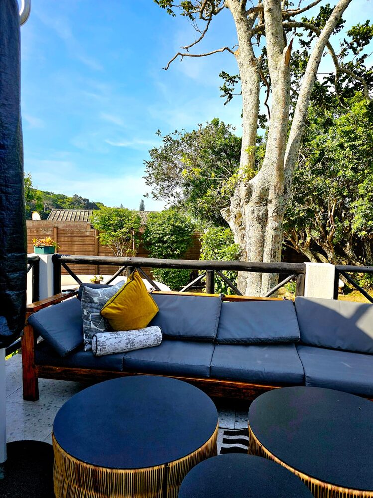 An outdoor lounge with sea view at Umdlalo Lodge, Umtentweni